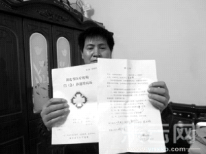 沈红霞丈夫向记者展示妻子的病历。